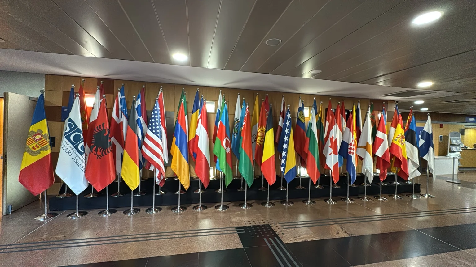 Montaje de banderas nacionales sobre pódium negro en el Centro de Congresos de Andorra la Vella